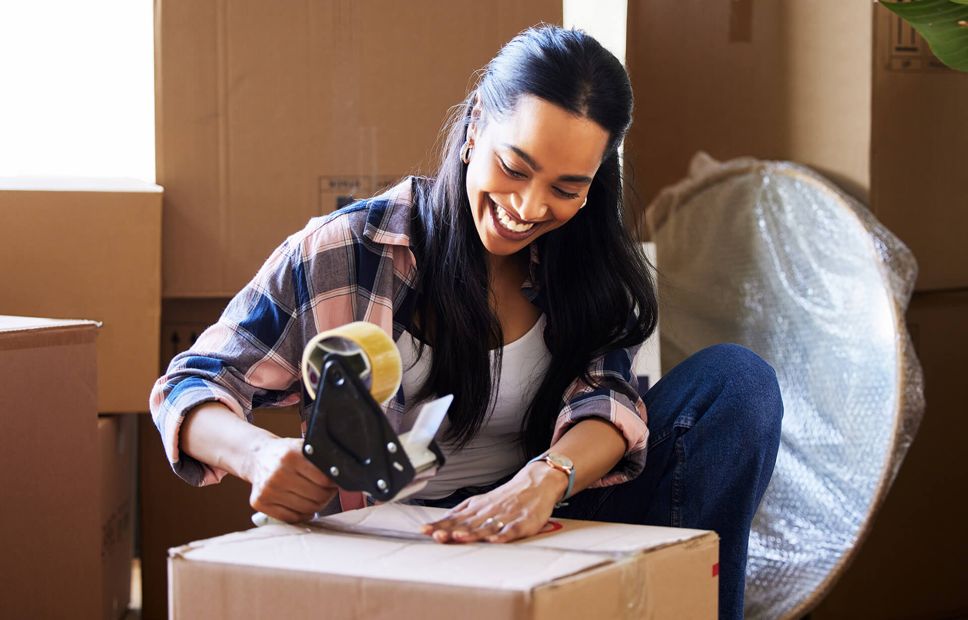 woman packing boxes after finding a homebuyer assistance program